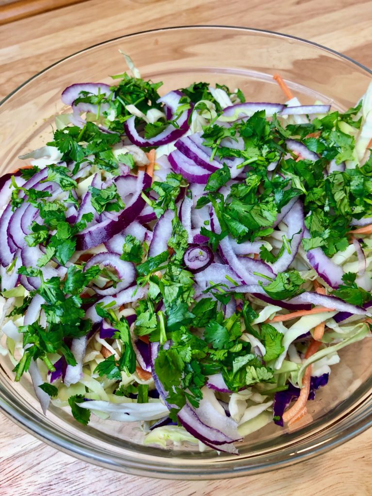slaw combined w fresh herbs, red onion and dressing