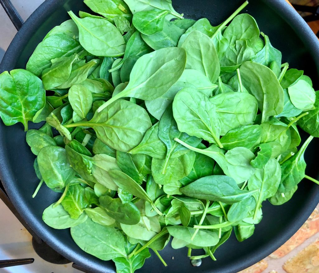 pan full of spinach for sautéing