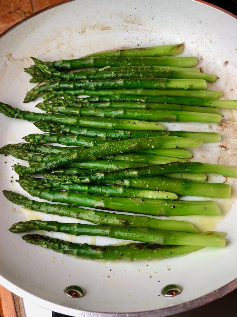 Cooking the asparagus in olive and seasoning with salt and pepper