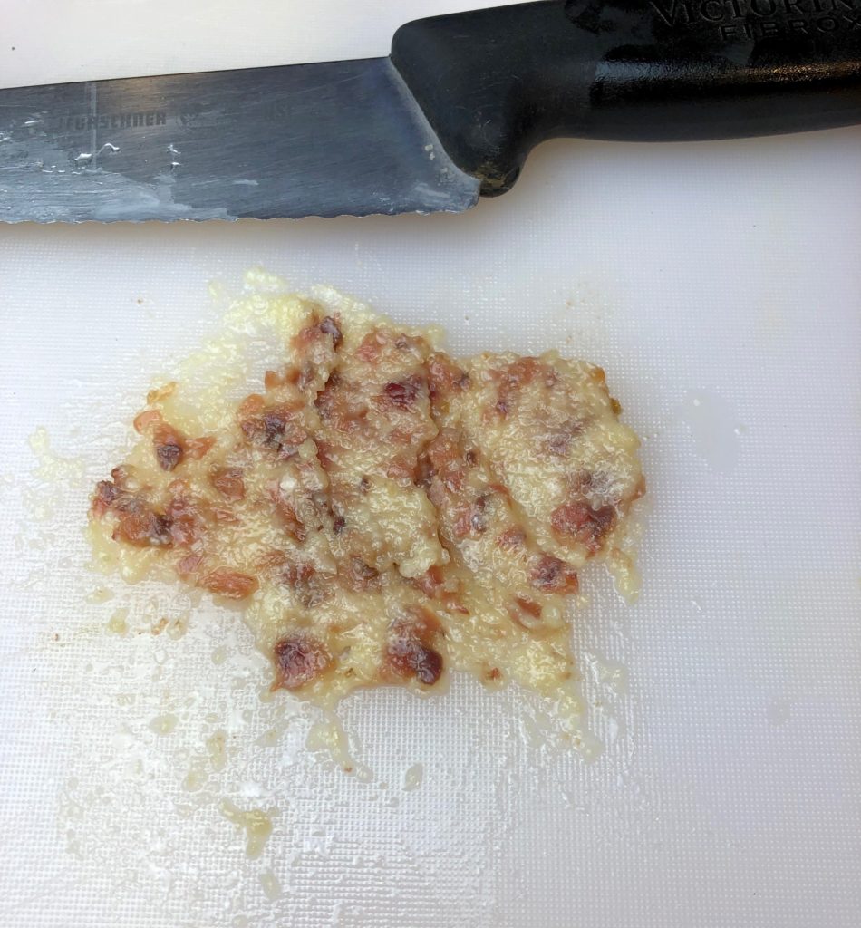 combining the garlic with the finely minced anchovies and salt to make a paste