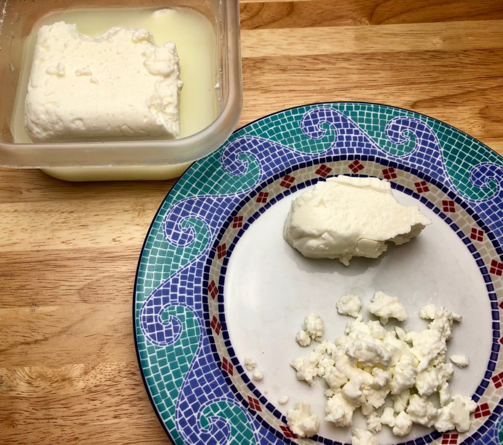 block of feta, a portion is crumbled