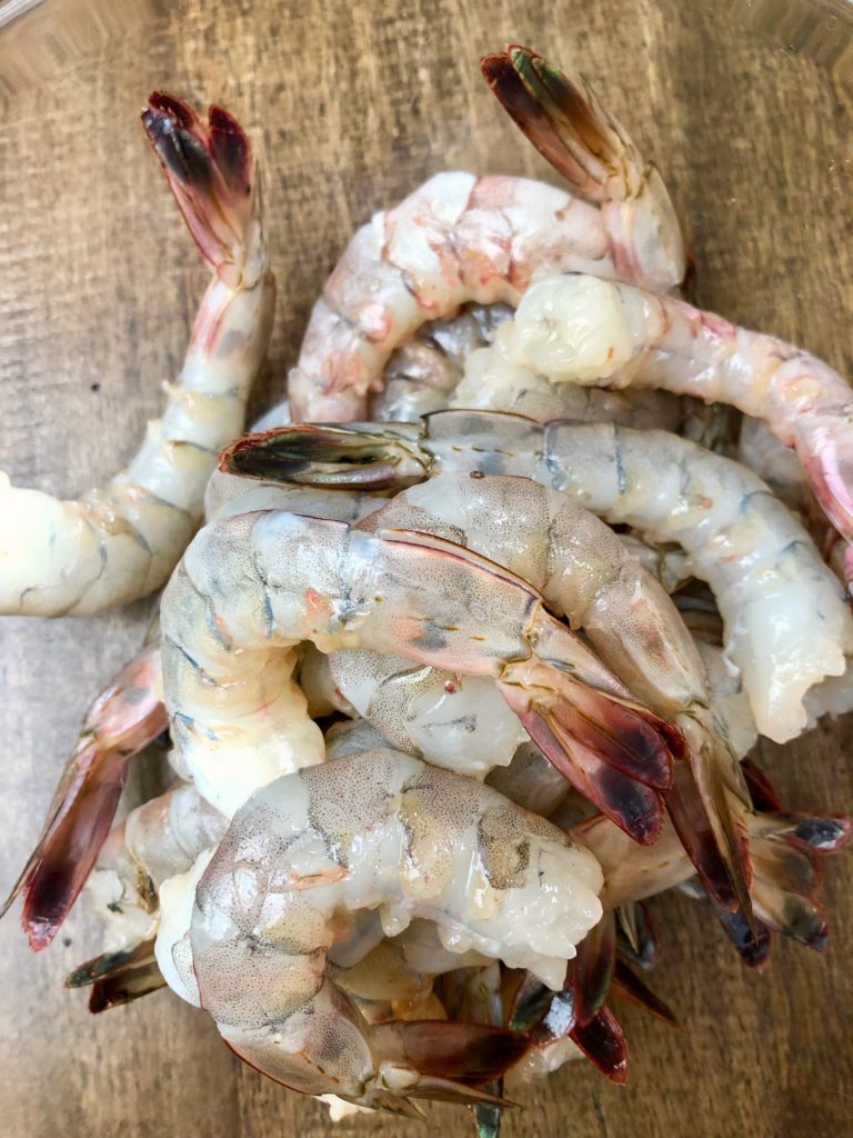 Peel shrimp in preparation for sautéing.