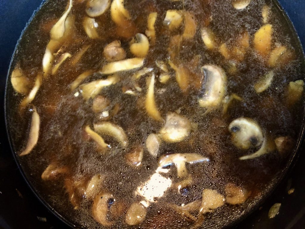 adding gluten free soy sauce, vinegar and water to the mushrooms