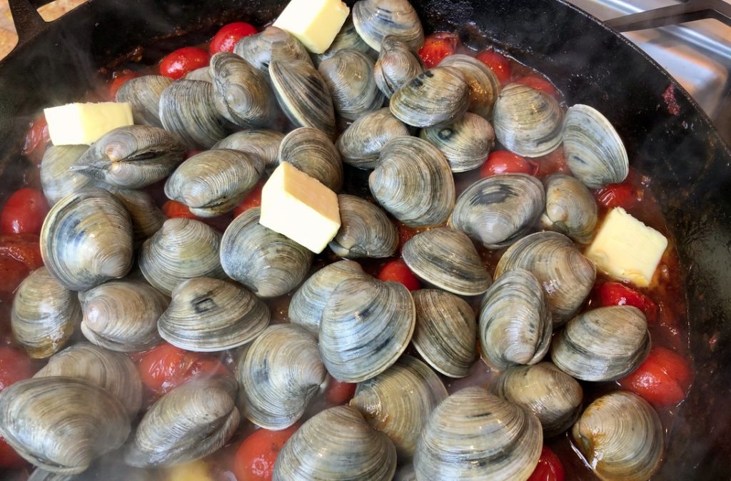 add clams and butter to the tomato broth