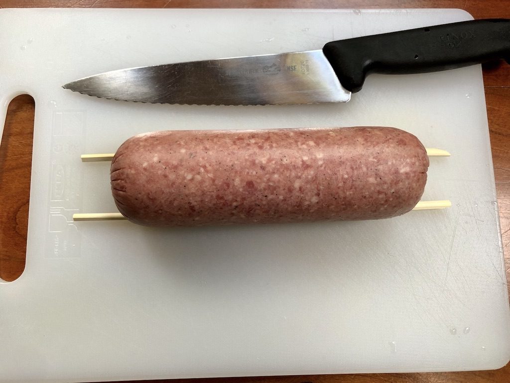 place a chopstick on each side of the salami