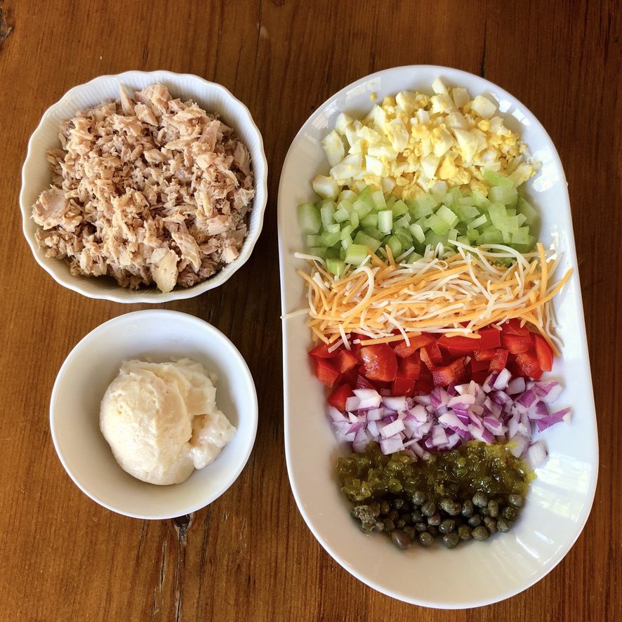 ingredients for The Works...chopped egg, celery, shredded cheese, peppers, onions, relish & capers
