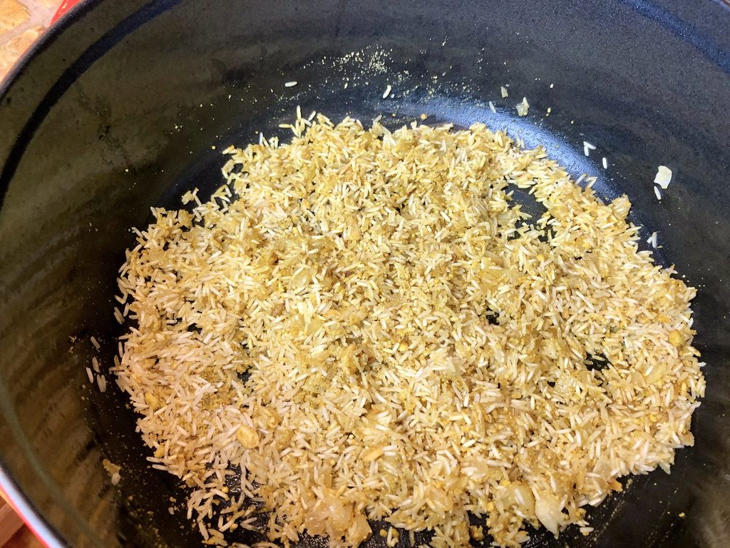 rice grains added to spices and onion mixture