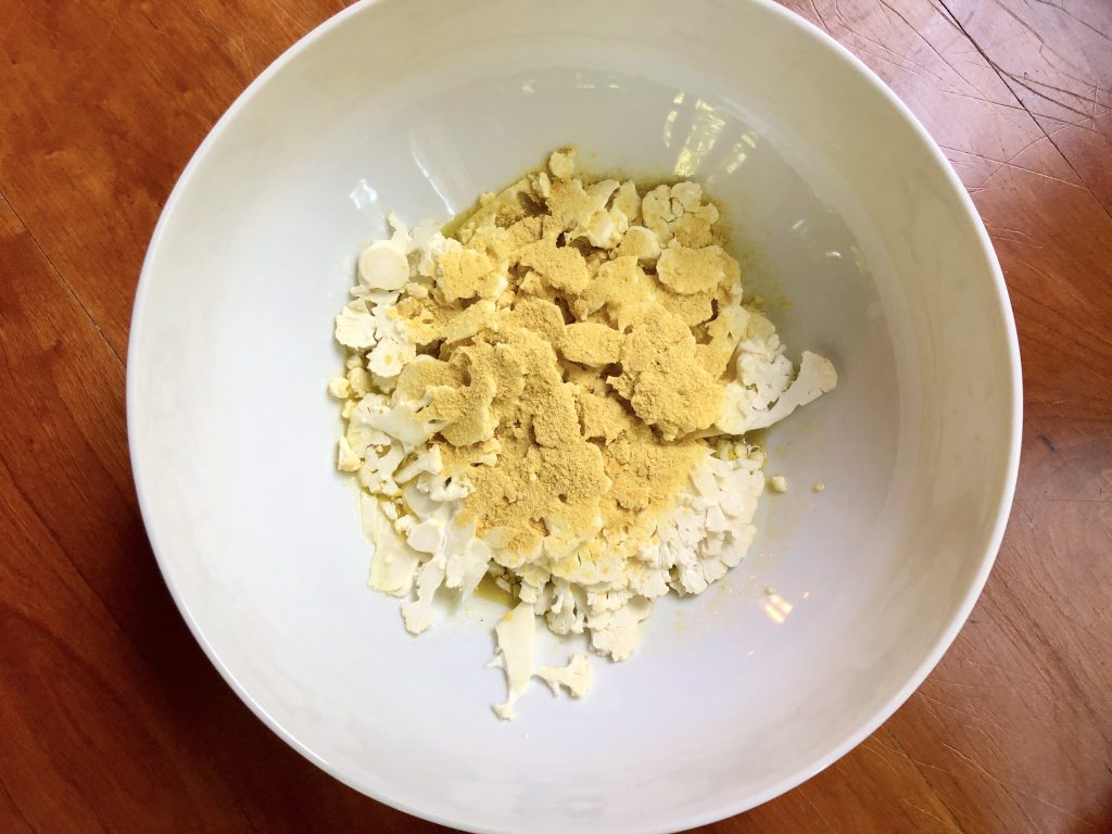 nutritional yeast added to cauliflower and dressing