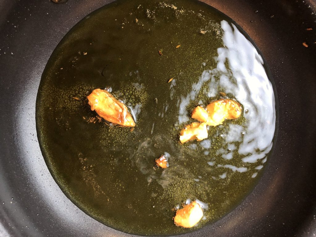 olive oil and garlic heating up in a small sauce pan