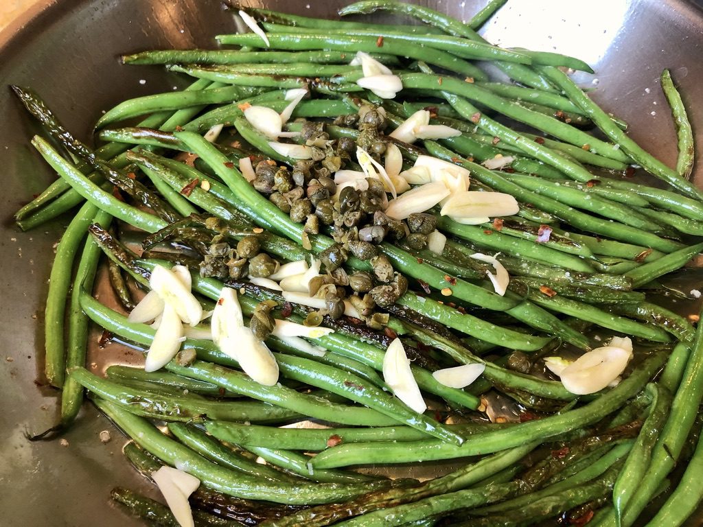 adding garlic slivers, chopped capers and red pepper flakes to the blistered green beans