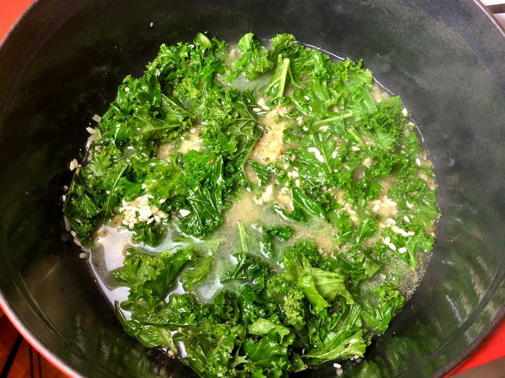 broth added to kale and arborio rice
