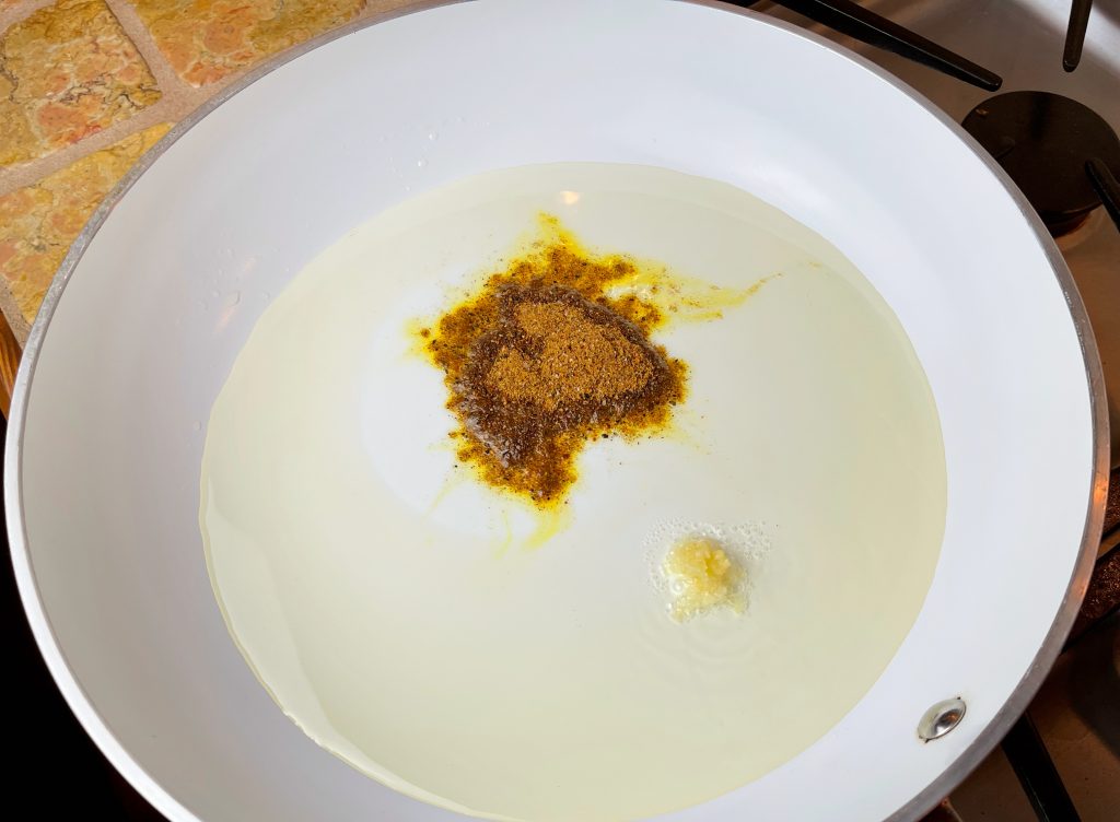 heating ras-el-hanot, oil, and garlic in a pan