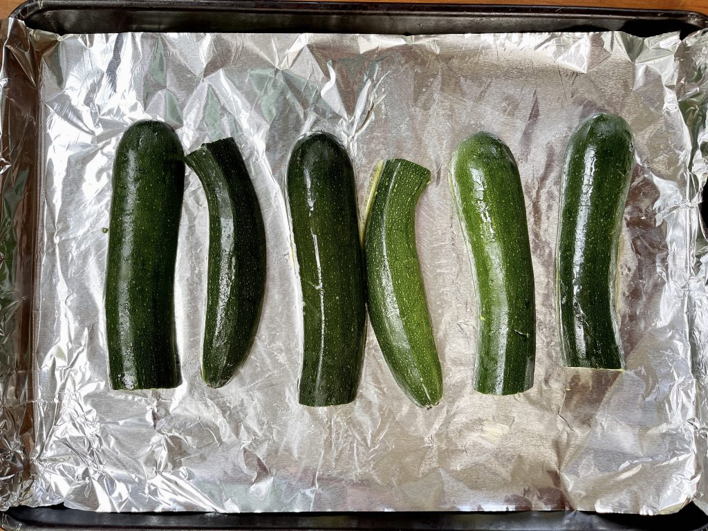 zucchini halves, cut side down on a foil-lined baking sheet