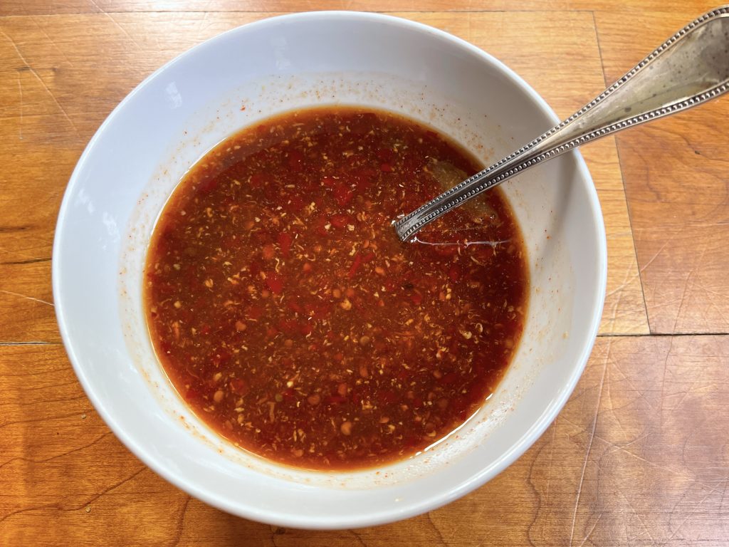 sauce ingredients combined together:  brown sugar, rice vinegar, hot chili paste, fish sauce, sriracha and ginger