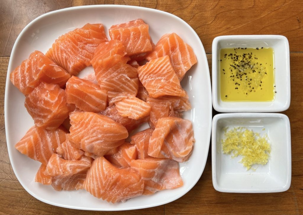 Salmon cut into chunks with olive oil, salt, pepper, and lemon zest