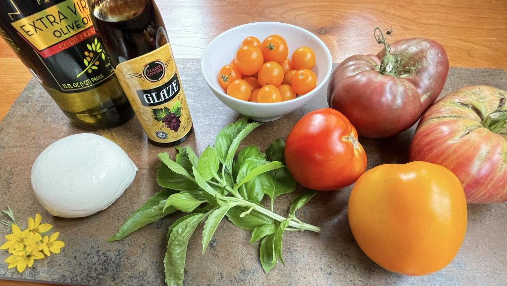 ingredients for Caprese Salad: tomatoes, fresh mozzarella, fresh basil, extra virgin olive oil, and balsamic blaze