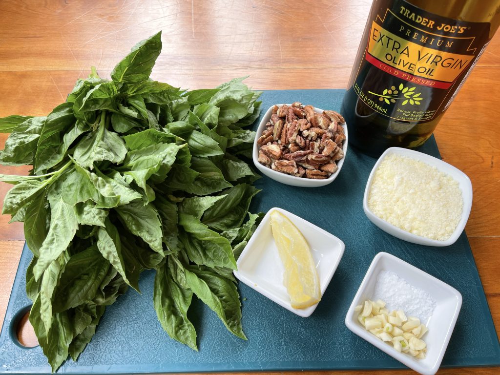 ingredients for pecan basil pesto: fresh basil, toasted pecans, parmesan, garlic, salt, olive oil, and lemon