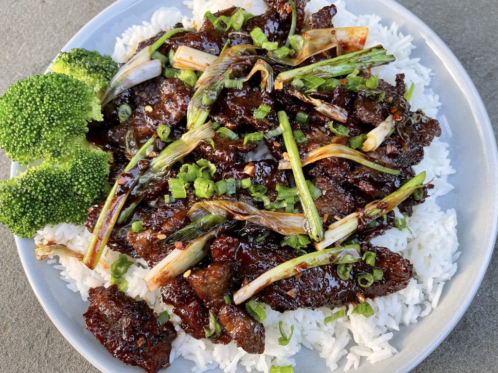 Sprinkle scallion greens and red pepper flakes over the beef and, if using the scallion whites, place them on top too.