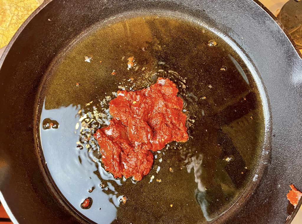 add spiced tomato paste to the pan.
