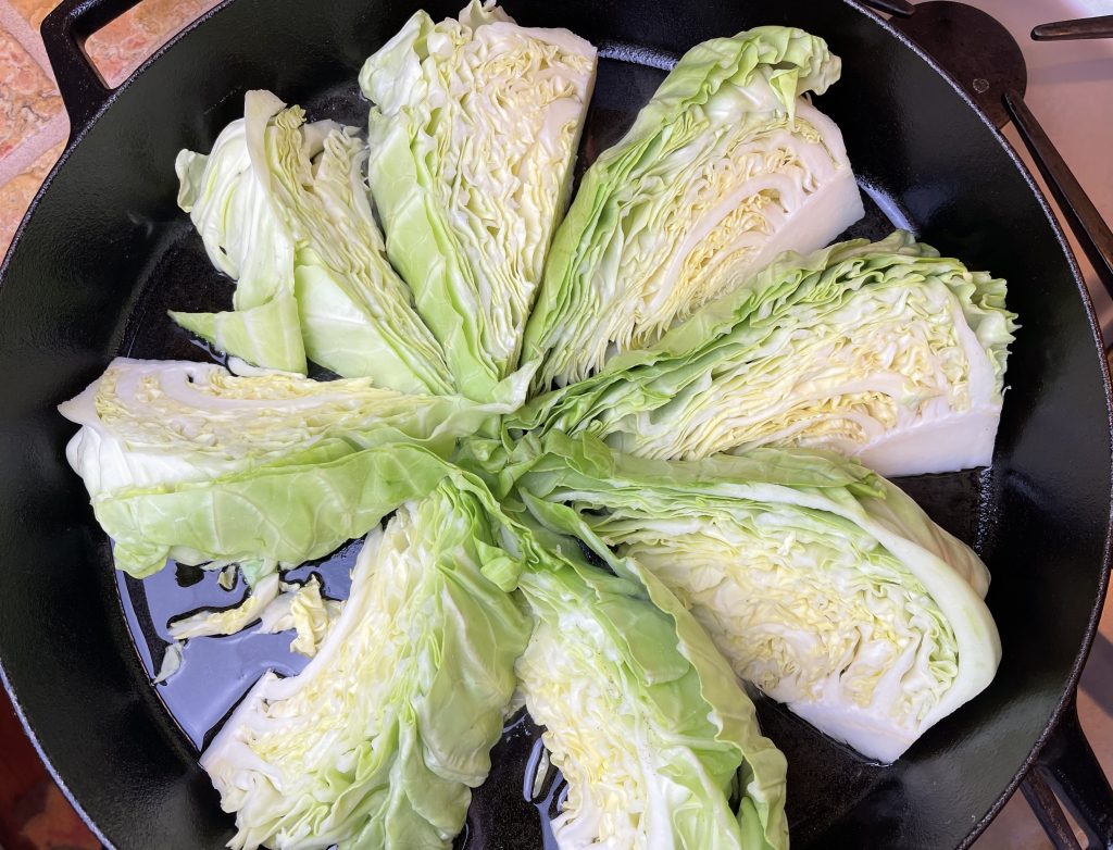 place cabbage wedges into the heated pan.  you may need to cook the cabbage in batches