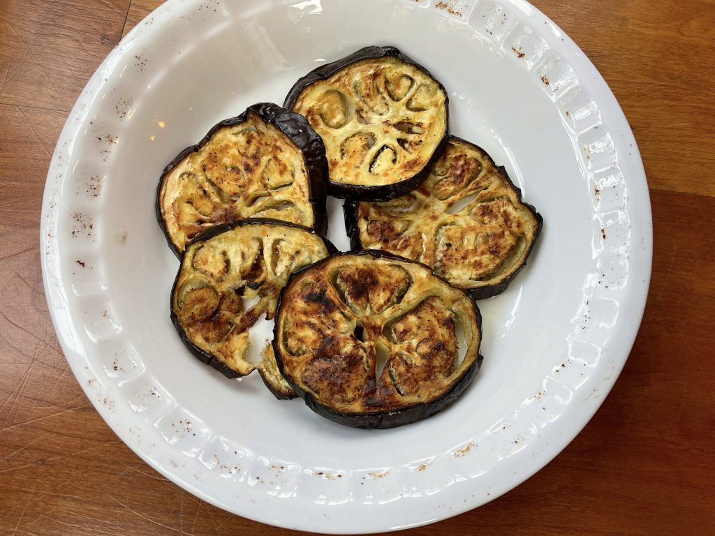 Place 4-5 eggplant slices in the bottom of the baking dish