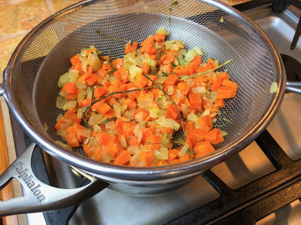 strain broth over medium saucepan, gently pushing down on veggies to exact all of the broth
