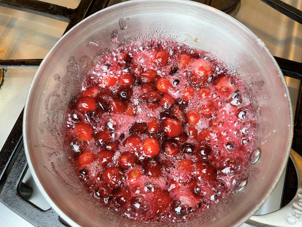 continue cooking cranberries until cranberries begin to pop