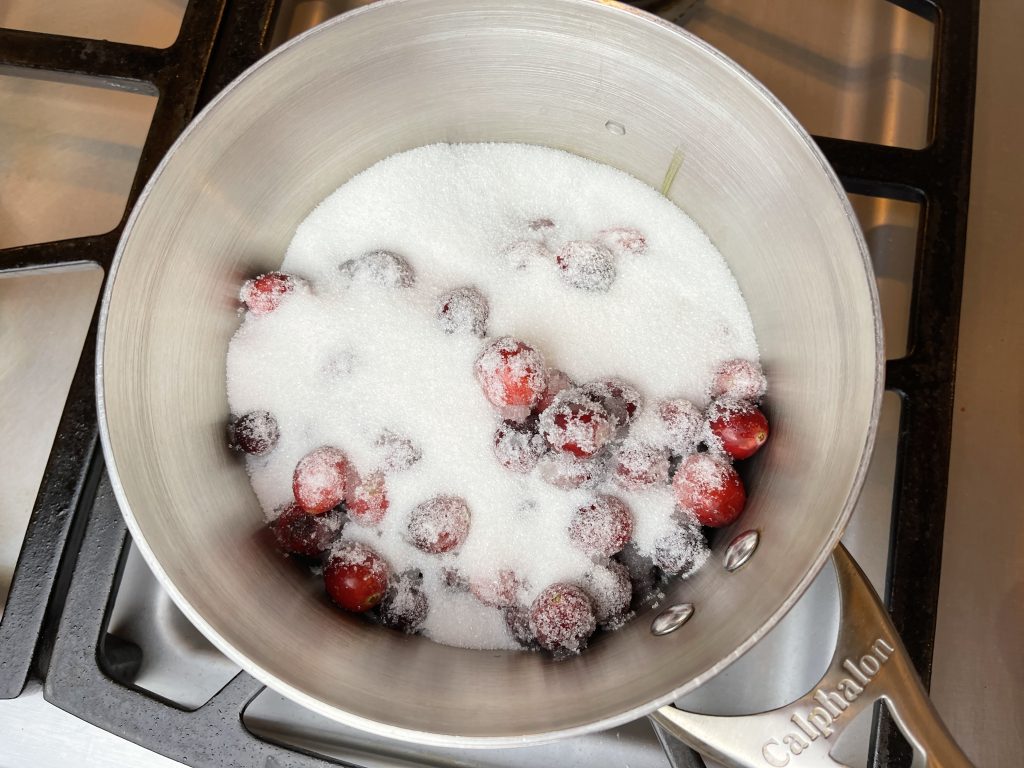 combine sugar and cranberries in a saucepan