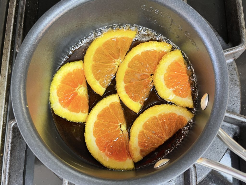 orange slices cooking in maple syrup