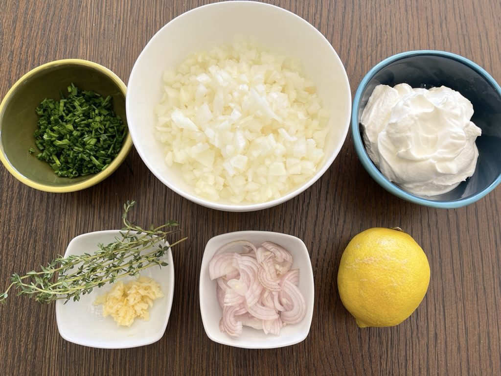 ingredients for homemade onion dip -  diced onions, sliced shallots, sour cream, lemon juice, thyme, chives and garlic