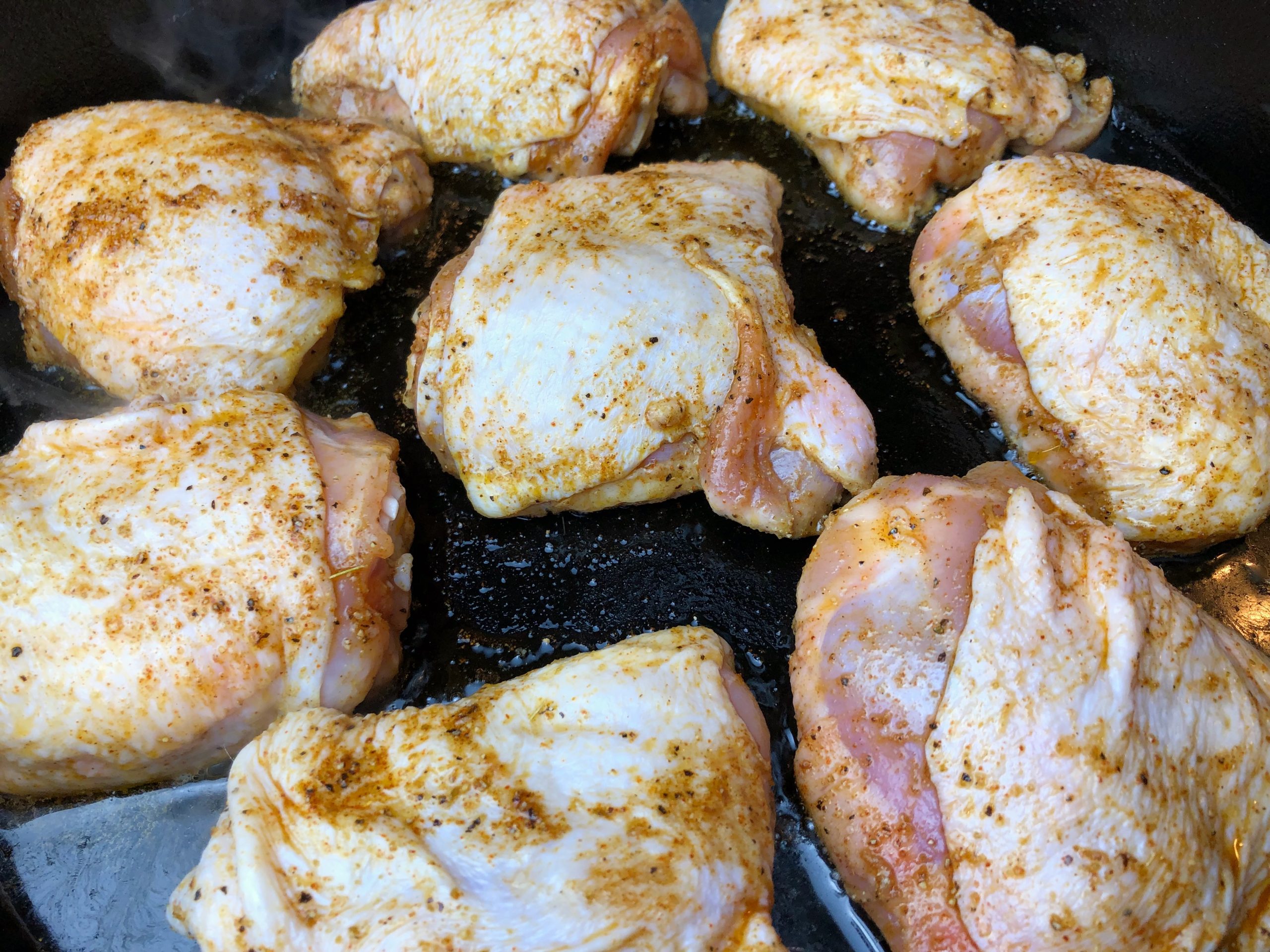 chicken thighs placed in the pan skin-side up