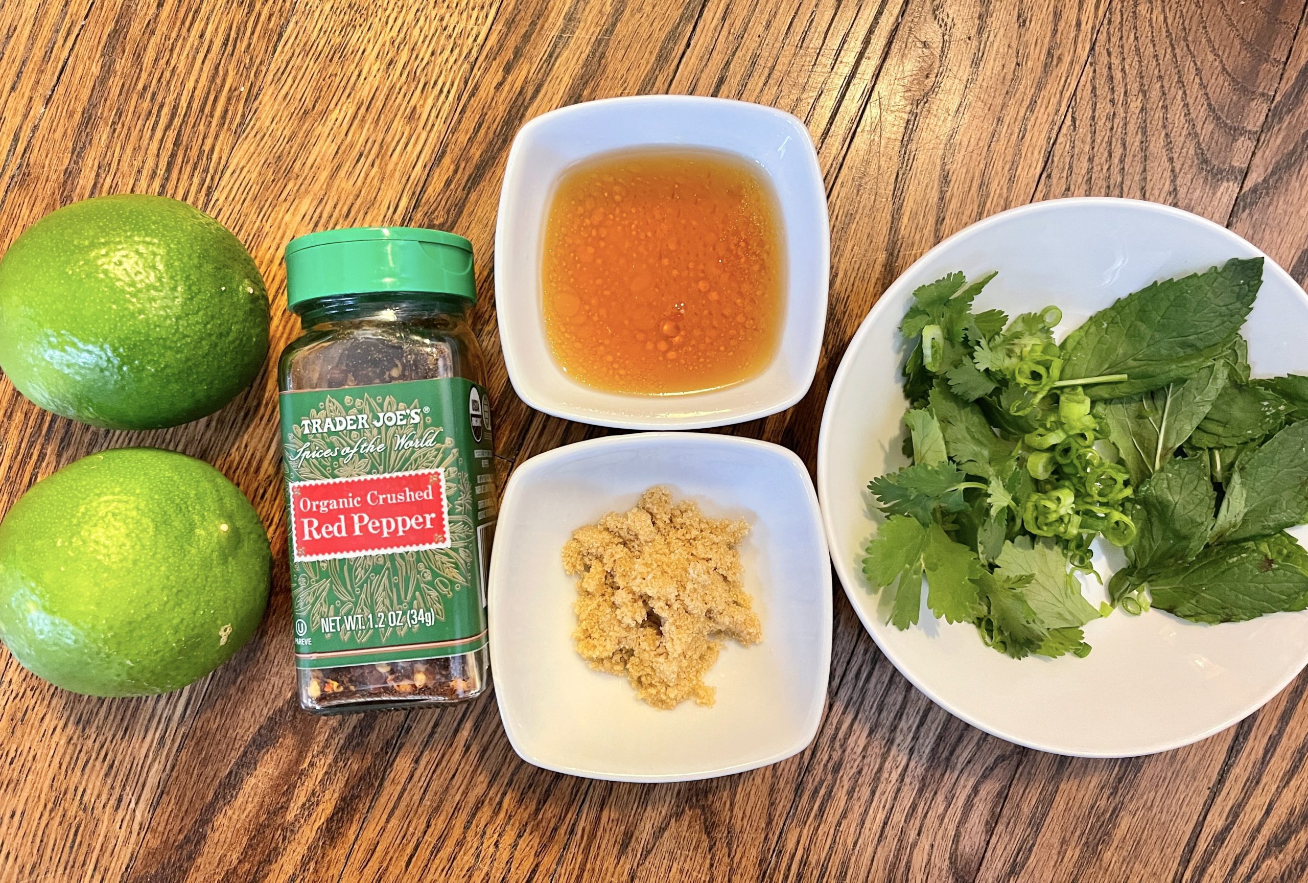 thai-style vinaigrette ingredients - fish sauce, lime juice, scallion, light brown sugar, red pepper flakes, chopped cilantro and mint