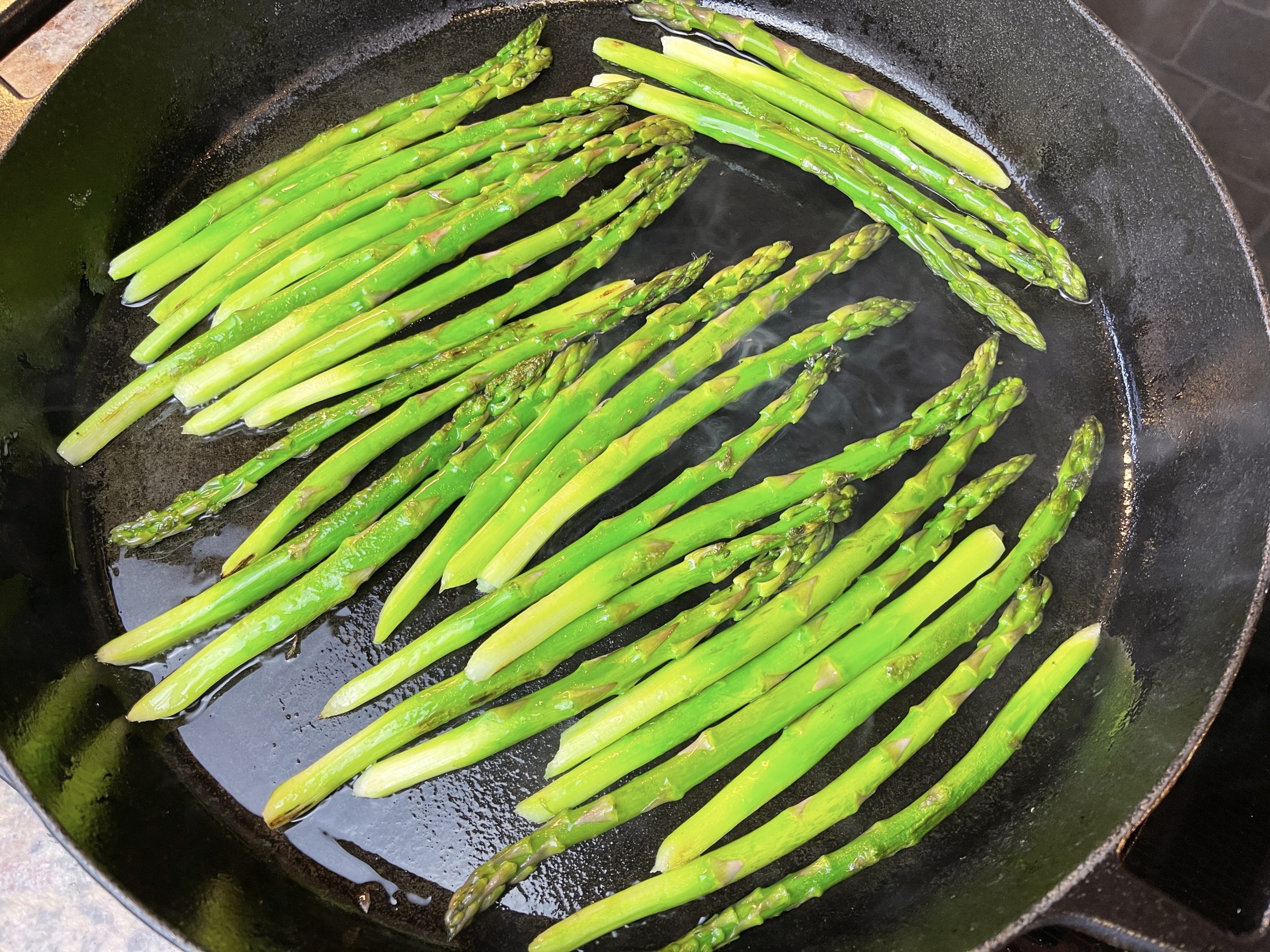Heat one tablespoon oil in a large nonstick pan over medium-high heat. Cook asparagus in a single layer, undisturbed, until slightly charred underneath, about 2 minutes. 