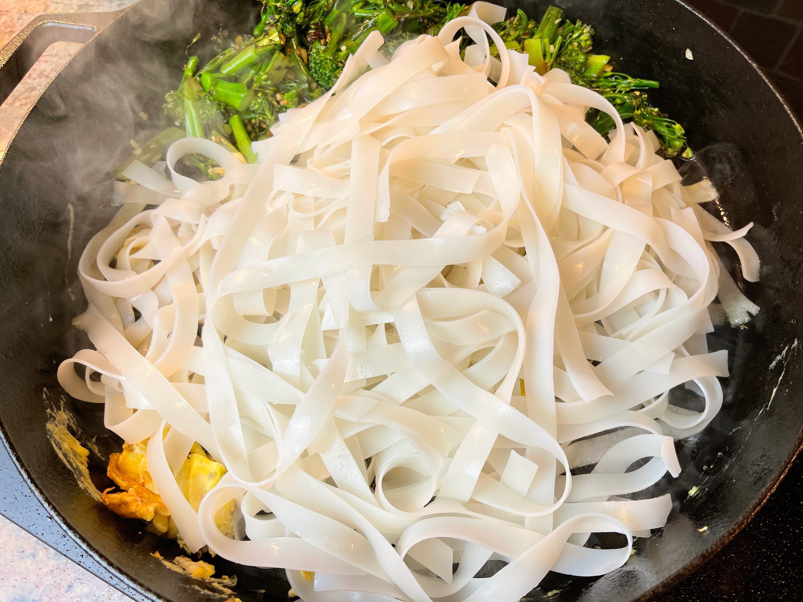 Add noodles to the pan and combine them with the egg and broccolini using tongs.