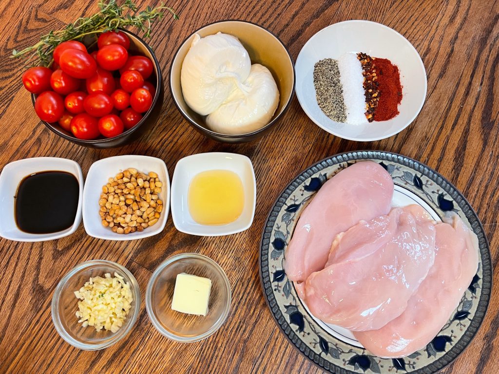 ingredients - chicken breasts, cherry or grape tomatoes, burrata, garlic, balsamic, honey, kosher salt, pepper, paprika, red pepper flakes, and toasted pine nuts