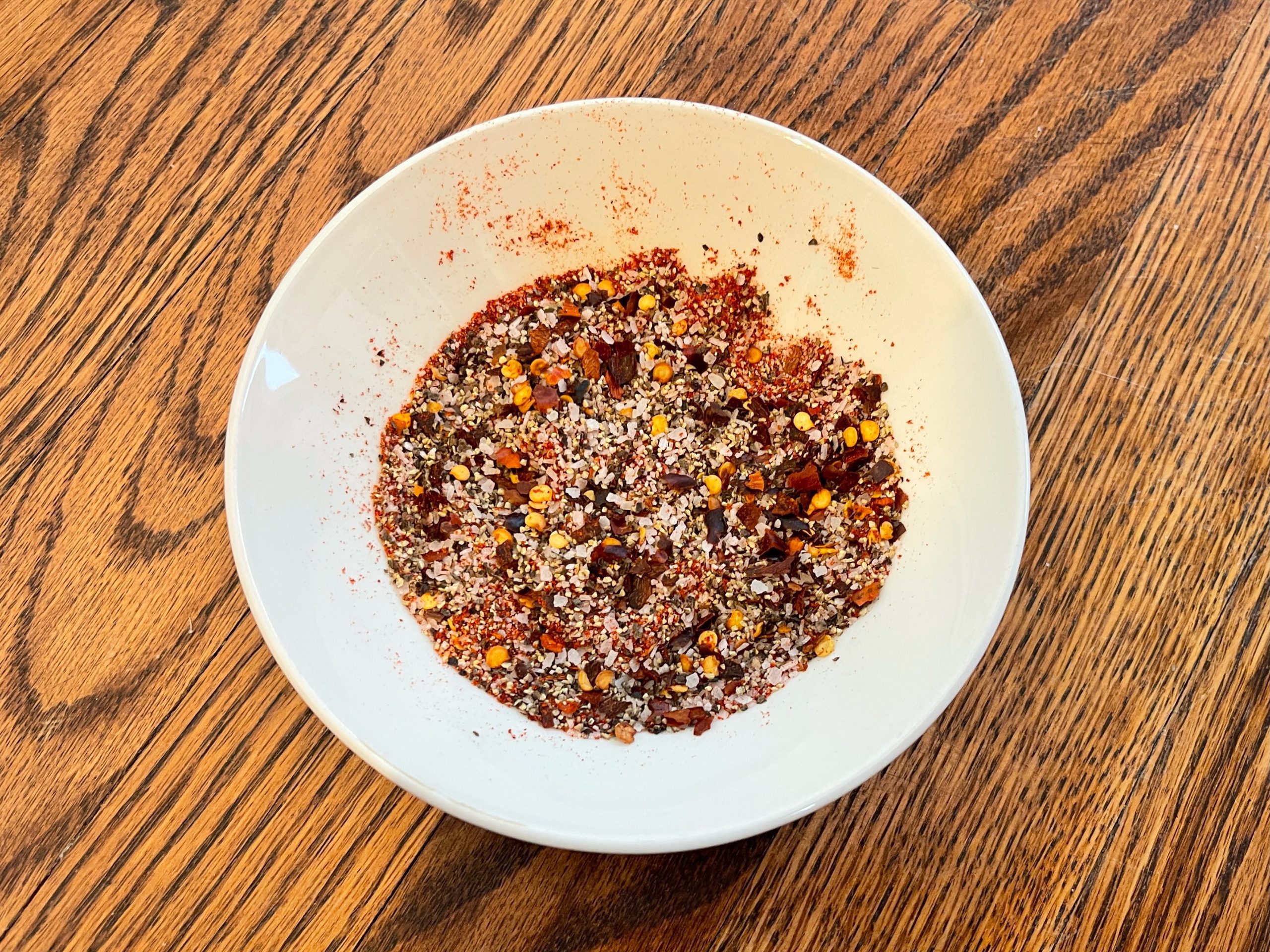 make the dry rub by mixing together the black pepper, kosher salt, paprika, and red pepper flakes together