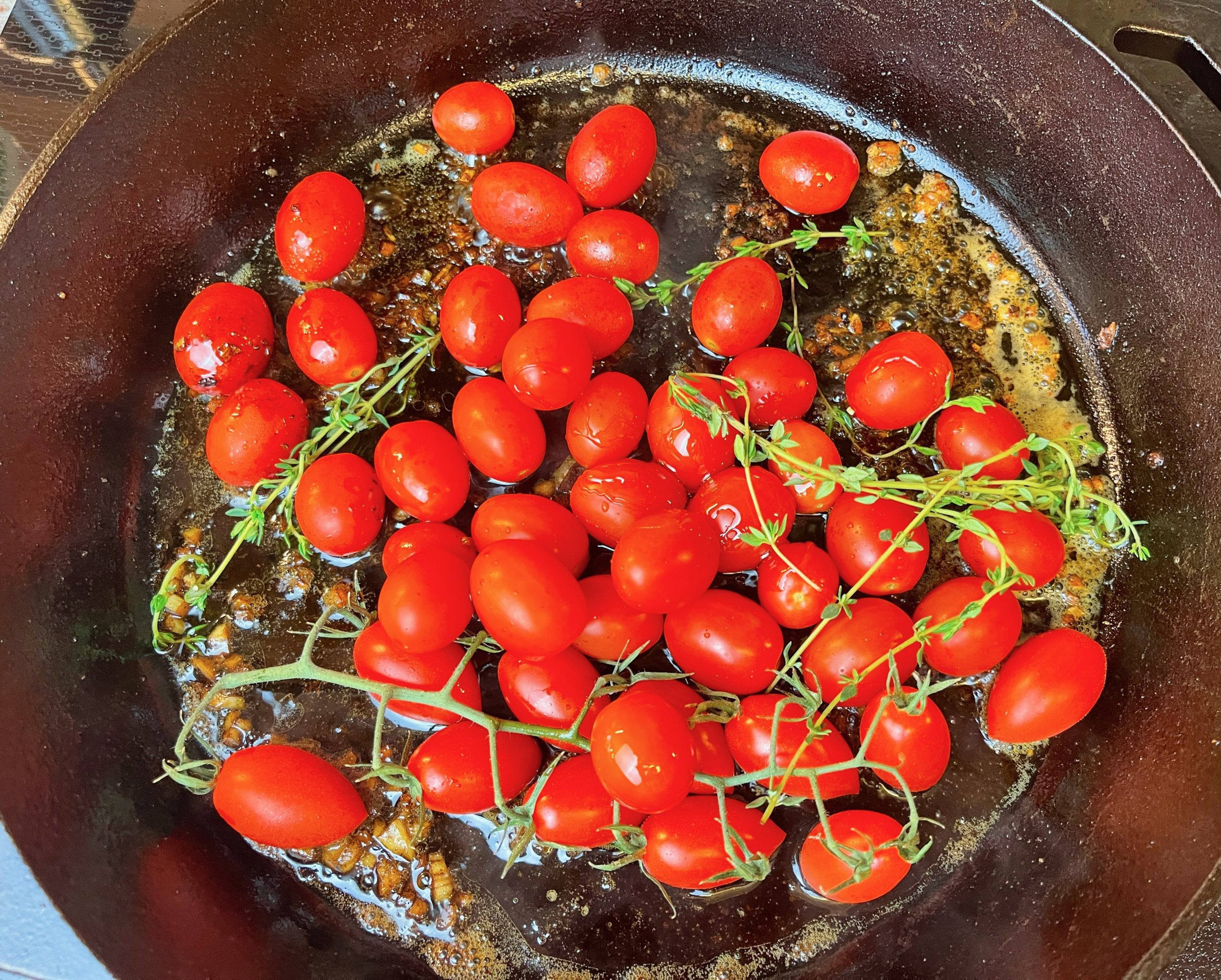 Add cherry tomatoes, and stir in balsamic vinegar, honey, and thyme sprigs.