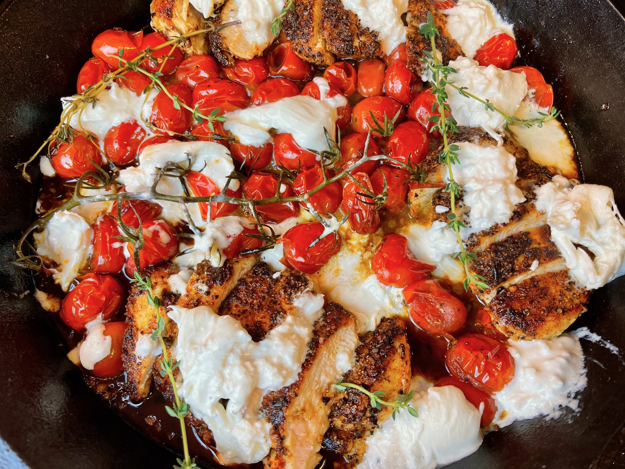 Break the burrata balls into pieces and place over the chicken and tomatoes and turn off the heat.