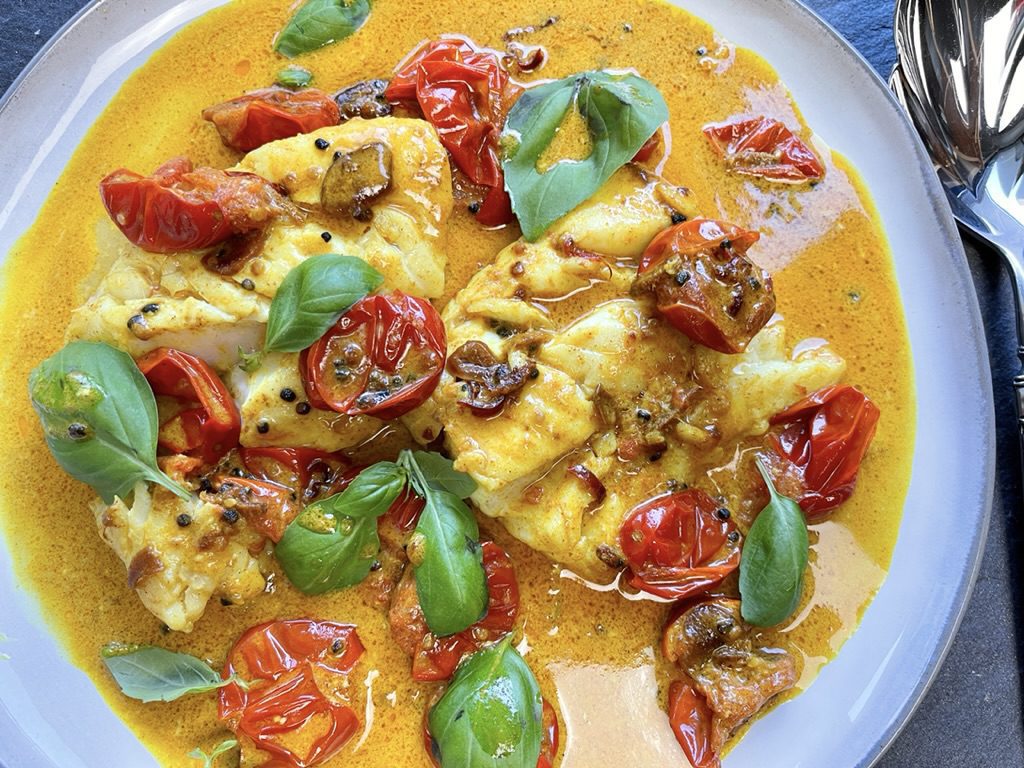 Transfer the cod to a platter with the tomatoes and curry.  Garnish with basil and spoon some of the curry onto the basil leaves. Finish with a squirt of lime.