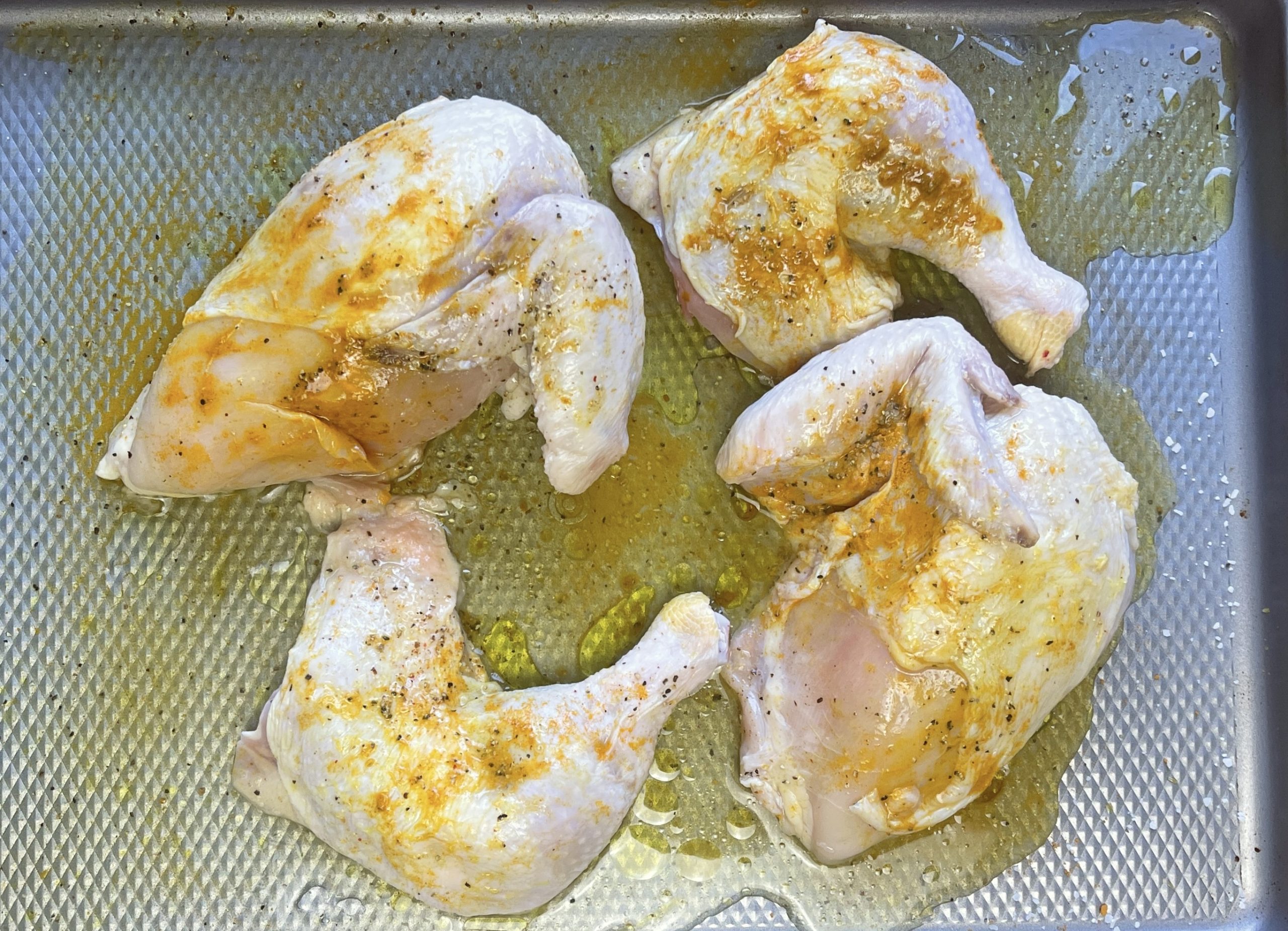 place chicken pieces on a rimmed baking sheet and coat chicken with turmeric, olive oil, salt, and pepper. Pour vinegar over chicken
