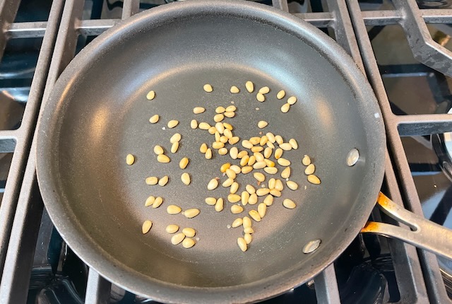 Place pine nuts in a pan over medium heat.