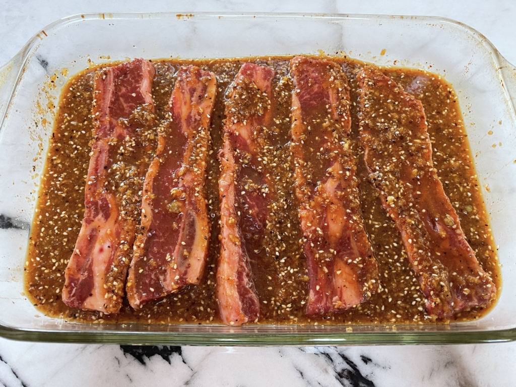 Place ribs in a large baking dish. Then pour marinade over short ribs and thoroughly coat the ribs.Let ribs sit for 10 mins.