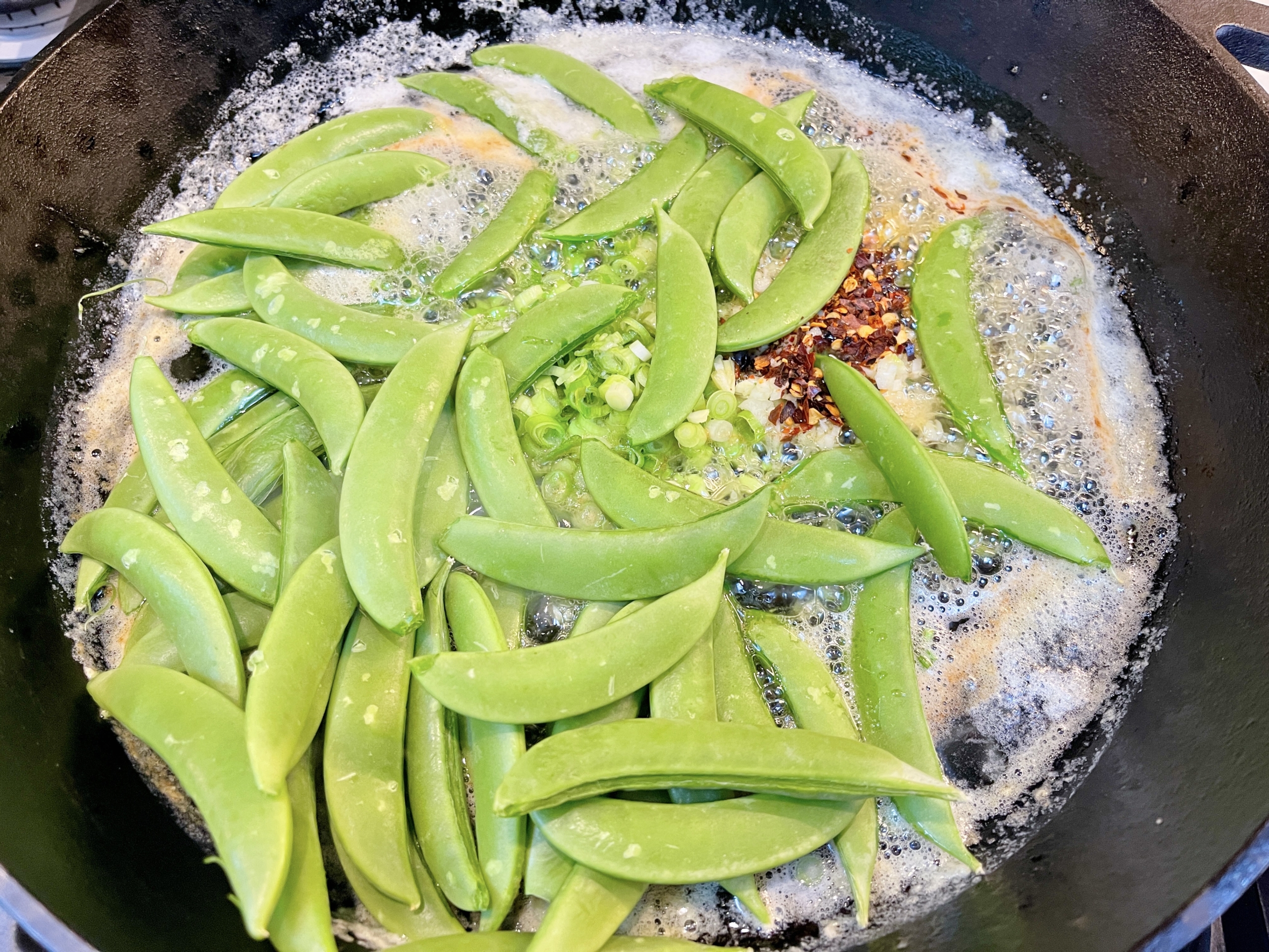 then add snow peas, white and pale green parts of the scallion, garlic and hot pepper flakes