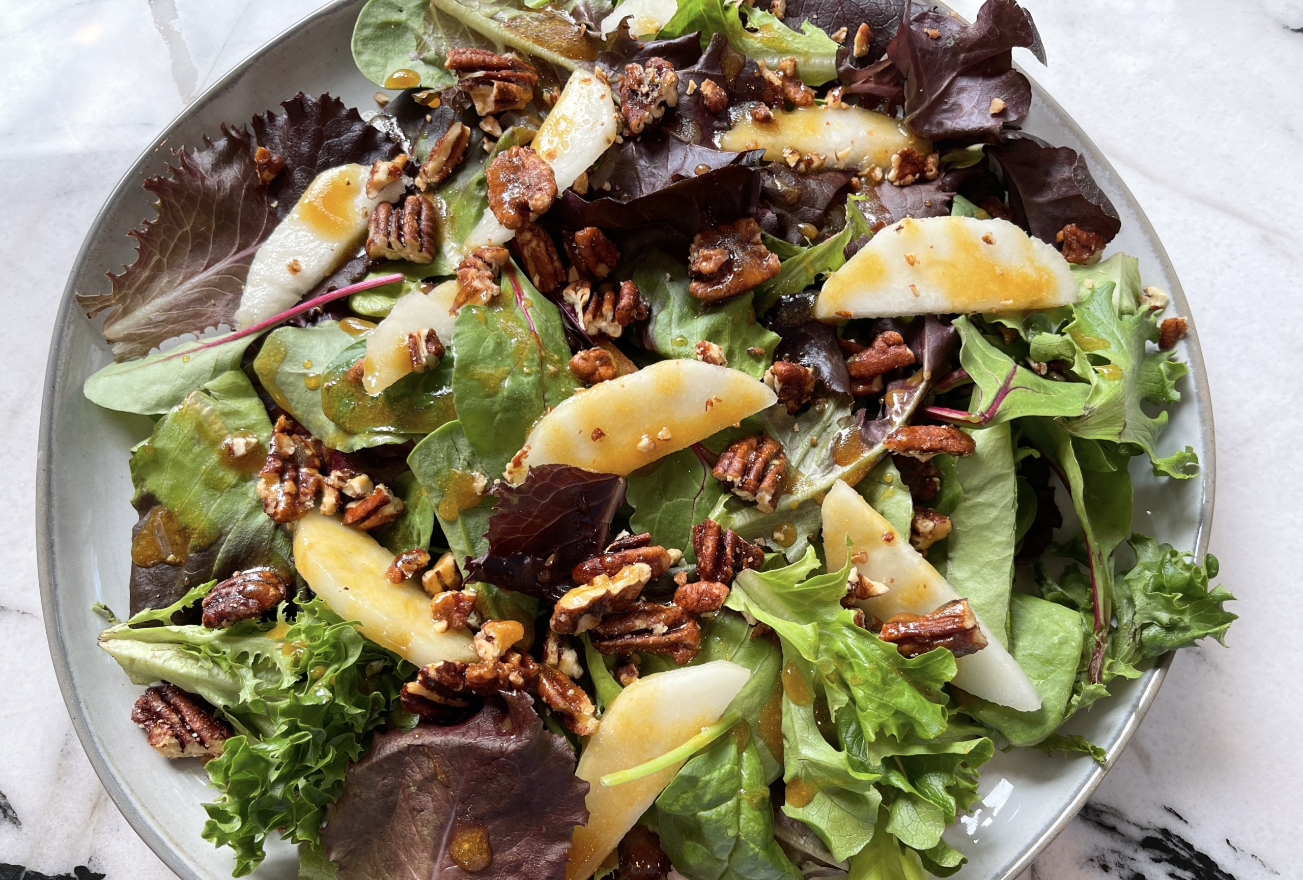place lettuce on a platter or in a bowl.  Top with sliced pears, candied pecans, and goat or blue cheese if desired.  Drizzle maple mustard dressing on top