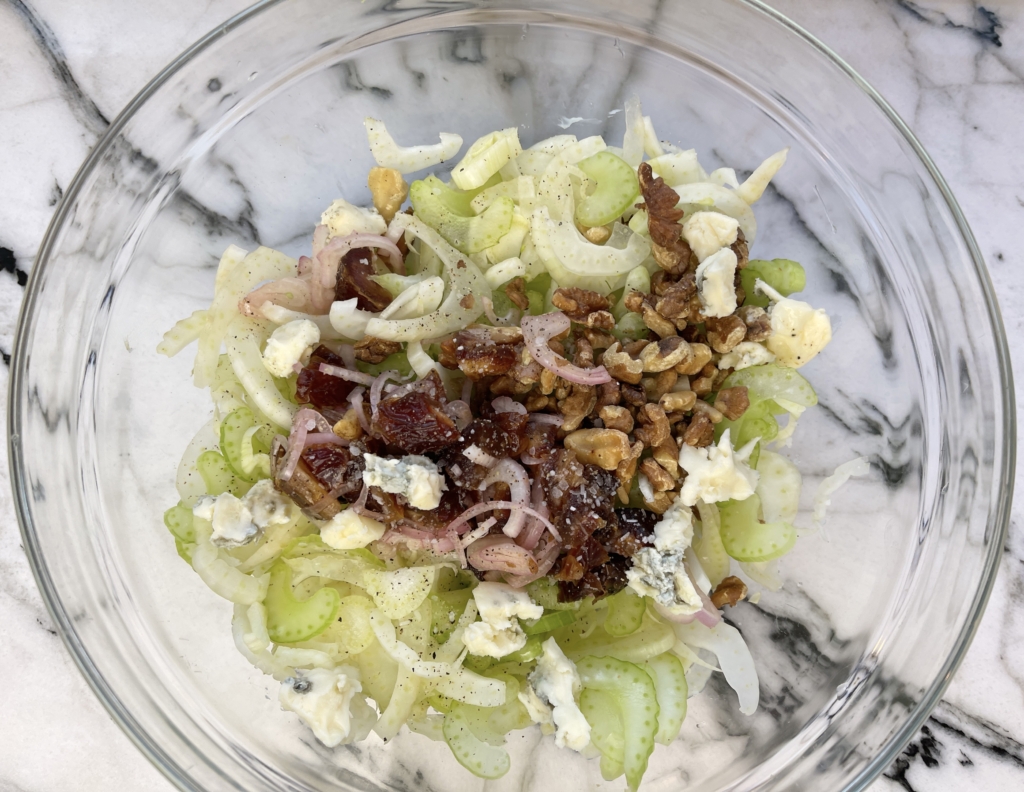 In a large bowl, add the fennel, celery, blue cheese, walnuts. Drain the figs (or dates) and shallots and add them to the bowl.