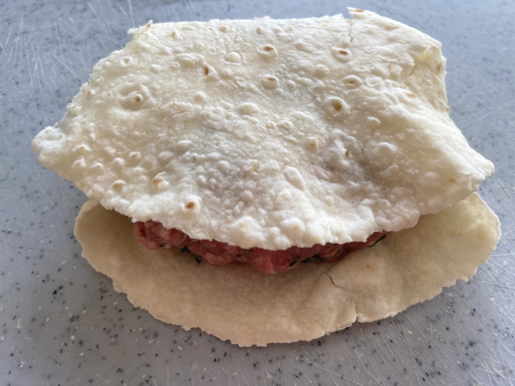Then bring bring the back part of the tortilla up and over. Press down slightly. 