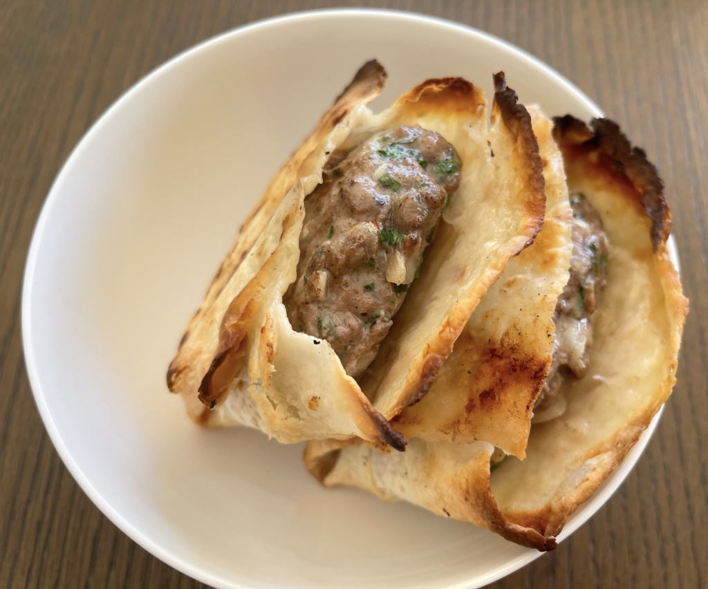 Take lamb pockets off the grill and place upright in a medium sized bowl to allow the lamb to rest but also to prevent the lamb juices from making the underneath side of the bread soggy.