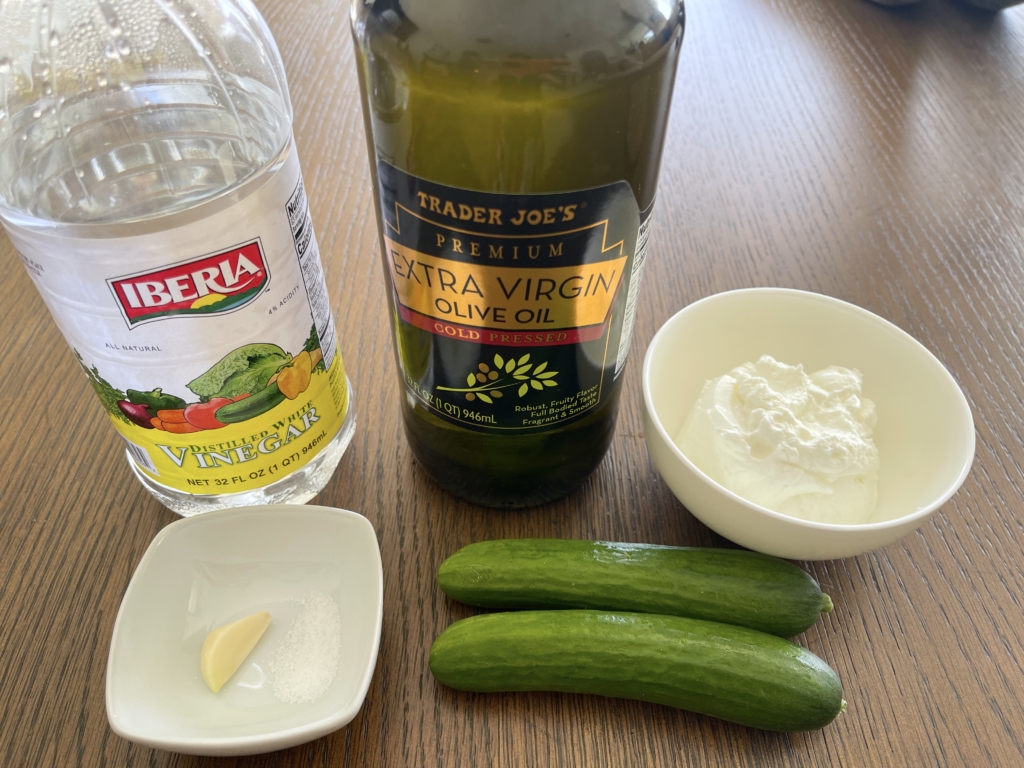 ingredients for tzatziki sauce - cucumbers, greek yogurt, olive oil, garlic, distilled white vinegar, squeeze of lemon (optional), fresh mint and/or dill (optional)