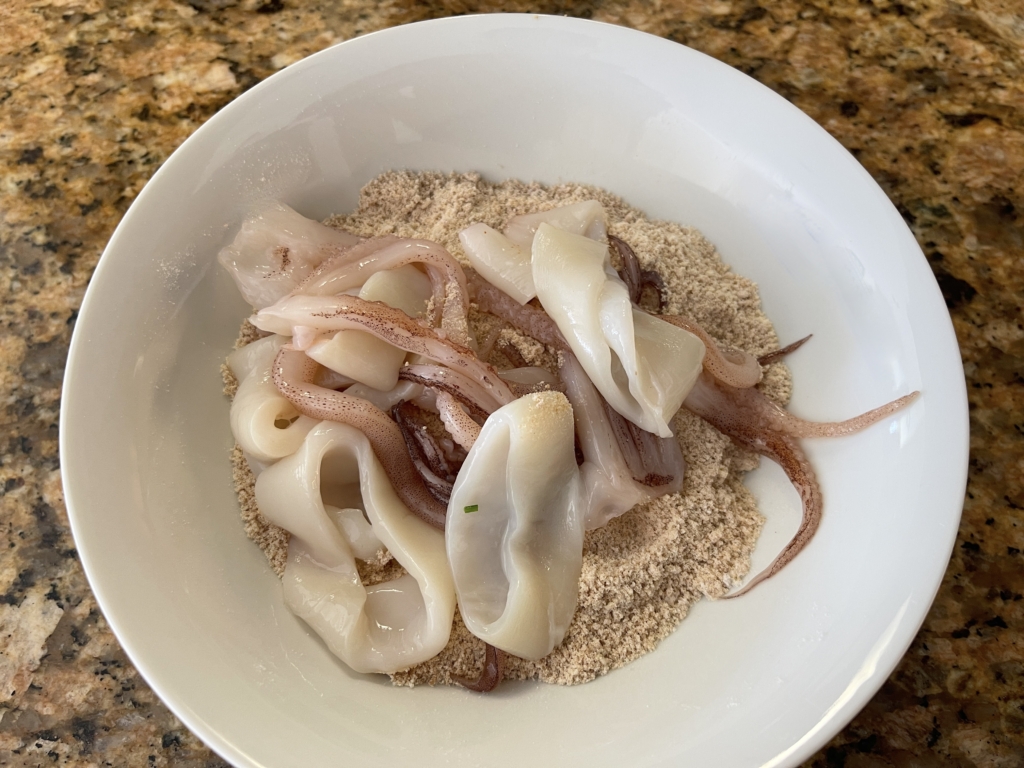 Place calamari into the graham cracker/flour mixture one batch at a time.