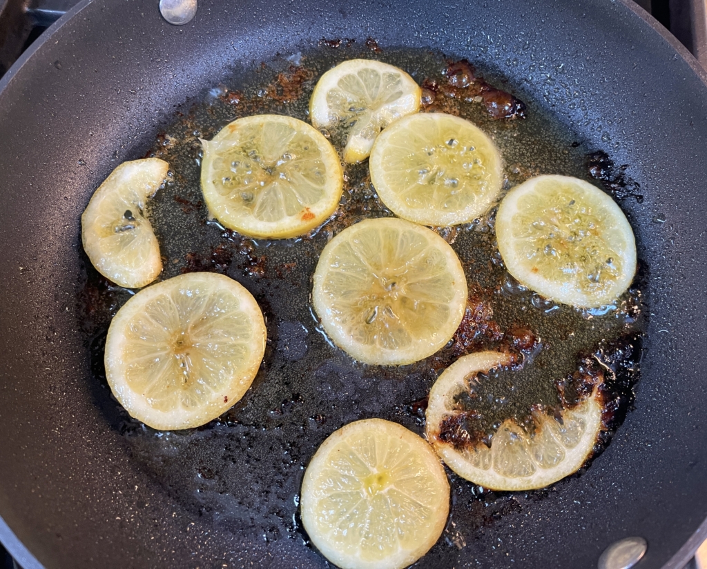 heat olive oil in a medium-sized pan over medium heat and place lemon slices in the pan